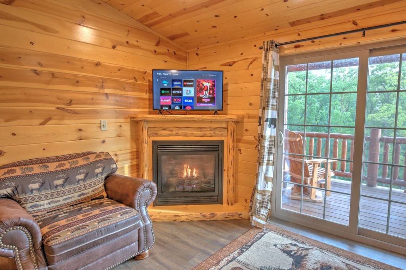 Living room with a lit gas fireplace and smart TV in the Aspen Suite
