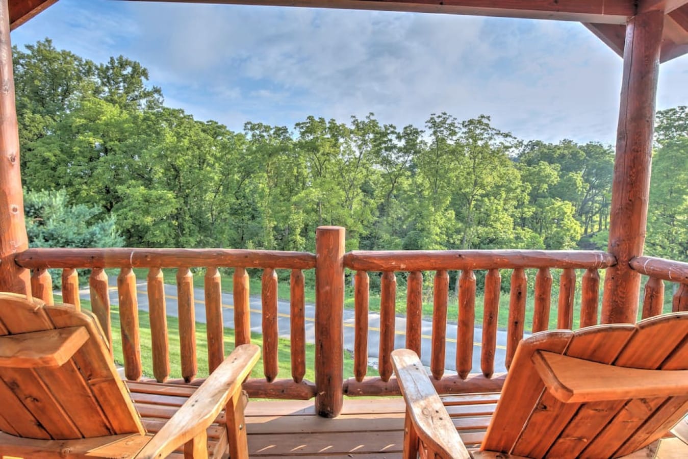 Log rocking chairs on a private porch overlooking the Amish Country countryside at Blessings Lodge